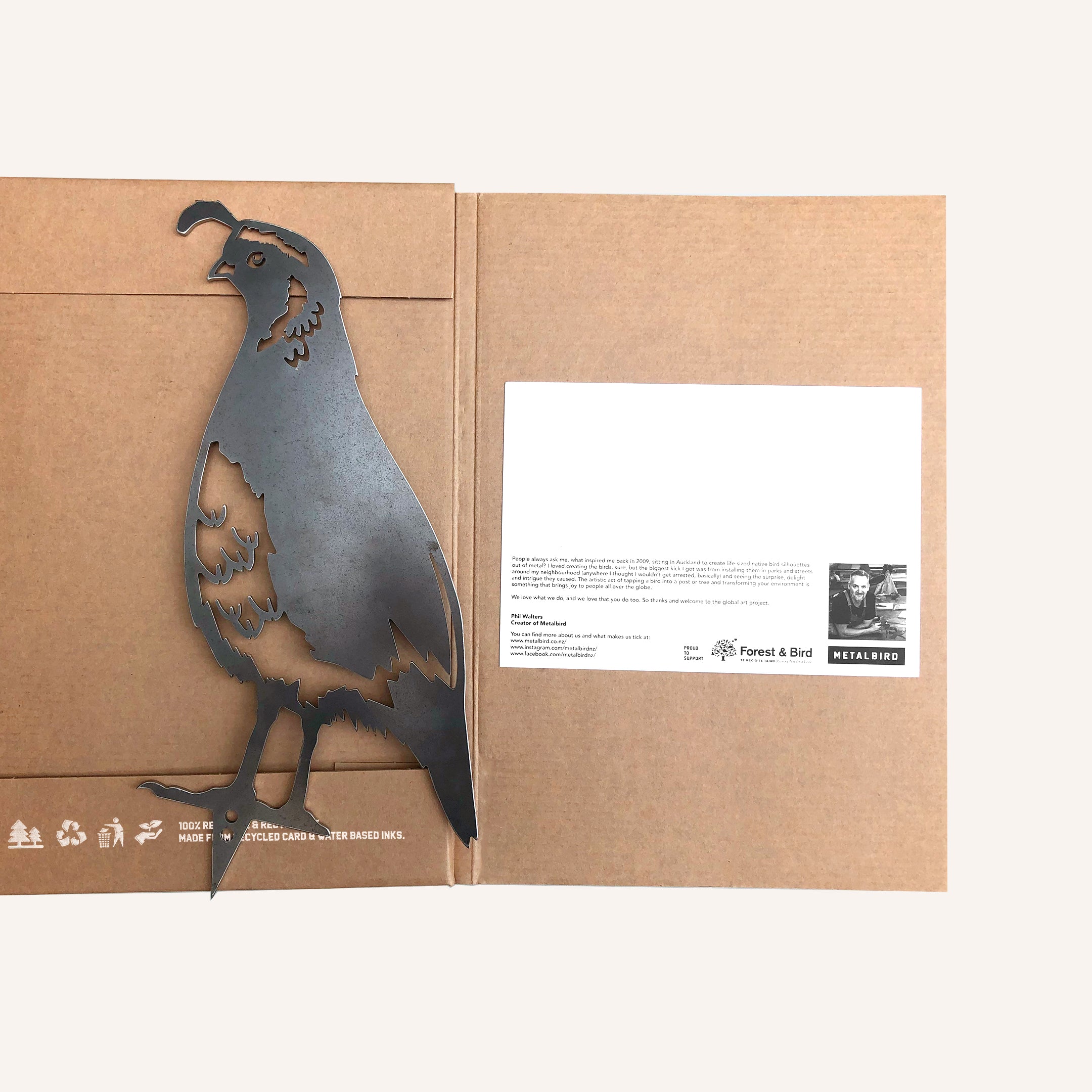 The Quail Mum & Mini Set by Metalbird New Zealand features a metal bird silhouette on brown cardboard with an info card. This charming decor makes a perfect garden gift idea in NZ.