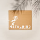 A brown cardboard envelope shows a white New Zealand Falcon on a branch, with “Kārearea: Wings of Glory” and Metalbird New Zealand branding. Palm leaf shadows cross this limited-edition Metalbird release.