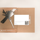 The Metalbird New Zealand Tūī Mum & Mini Set comes flat-packed in a cardboard envelope with a metallic bird art piece—ideal for Mother’s Day—included are an insert with printed text and a black-and-white photo on white.