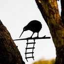 The Metalbird Seconds - KIWI AND LADDER by metalbird features a charming metal kiwi and ladder between trees. This discounted piece has minor imperfections, making it a unique addition to your collection.