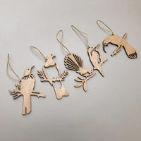 Five festive bird silhouettes—Winged Hangers by Metalbird New Zealand—are arranged in a row on a light gray background. Each sustainably made decoration features a string loop for hanging. Made in Aotearoa.