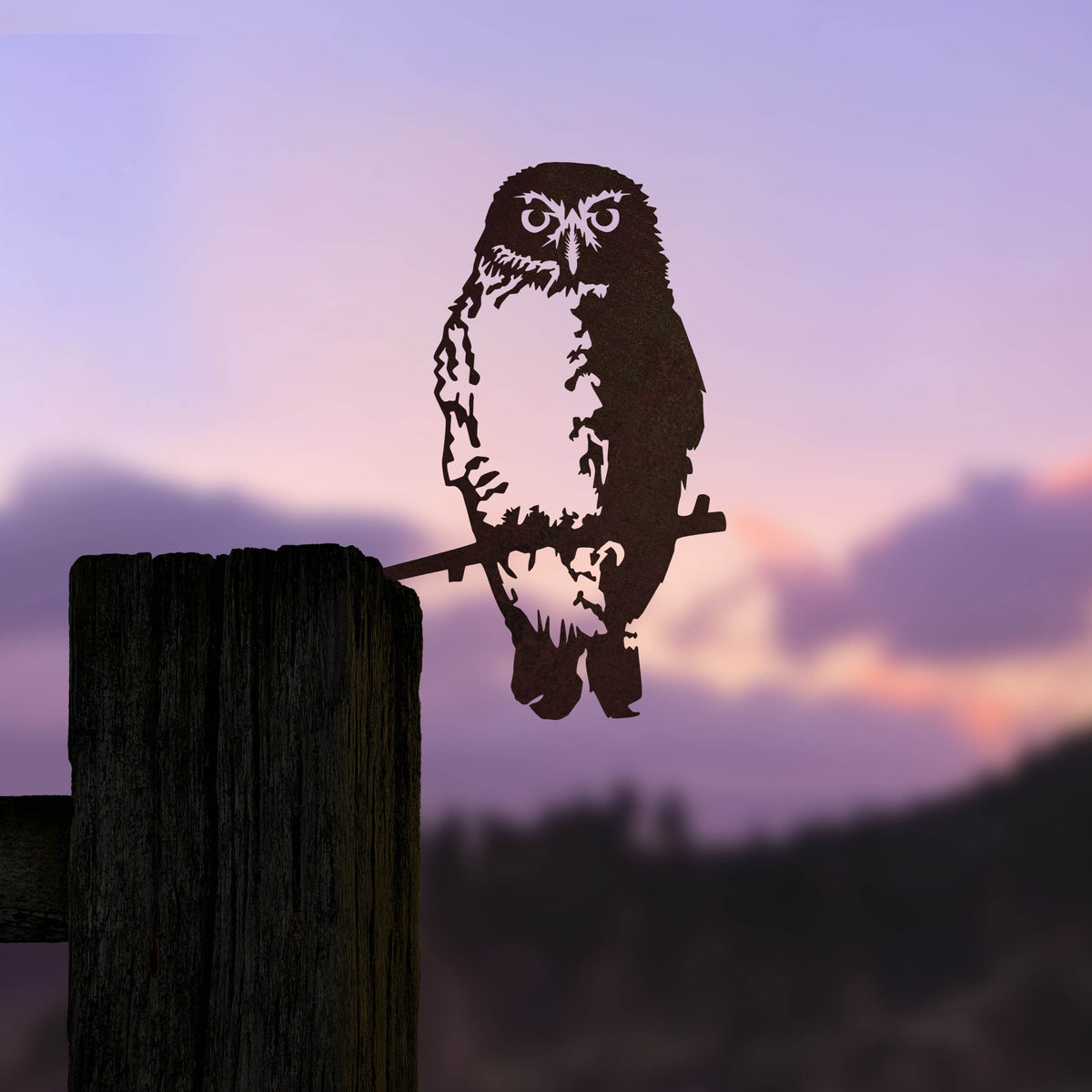 Ruru steel silhouette mounted beside a timber post against a pink sunset.
